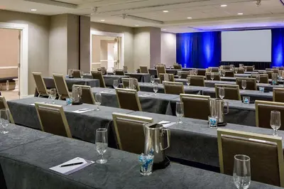 a conference room with tables and chairs and a screen at Hyatt Regency Cleveland at The Arcade in Cleveland
