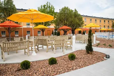 a group of tables and chairs with umbrellas at Cedar Point's Express Hotel in Sandusky