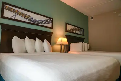 a hotel room with a large bed with white pillows at Cedar Point's Express Hotel in Sandusky