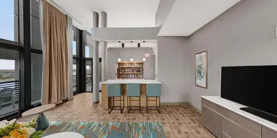 a living room with a table and a fireplace at Hilton Garden Inn Toledo Downtown in Toledo