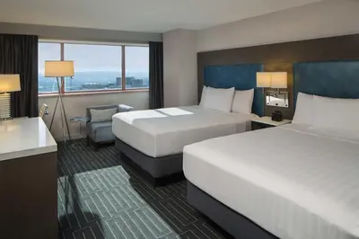 a hotel room with two beds and a desk at Hyatt Regency Cincinnati in Cincinnati
