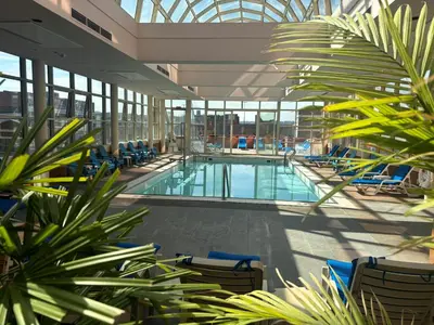 an indoor pool with chairs and plants in a building at Hyatt Regency Cincinnati in Cincinnati