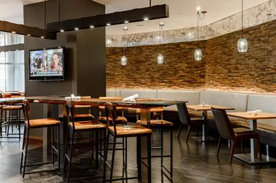 a dining room with tables and chairs and a tv at Hyatt Regency Cincinnati in Cincinnati