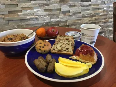 a plate of breakfast food on a wooden table at Best Western Port Clinton in Port Clinton