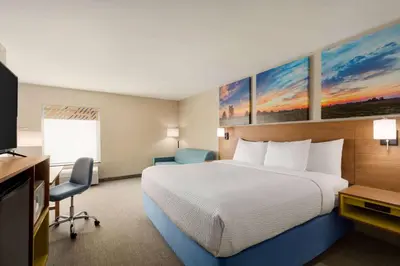 a hotel room with a bed and a television at Days Inn by Wyndham Hillsboro in Hillsboro