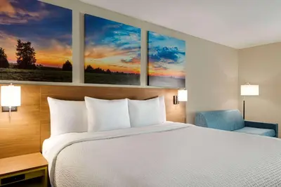 a bed in a hotel room with two paintings on the wall at Days Inn by Wyndham Hillsboro in Hillsboro