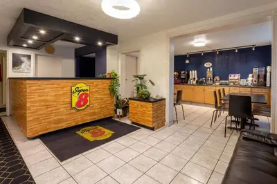 a lobby with a restaurant with a counter and a bar at Super 8 by Wyndham Wooster in Wooster
