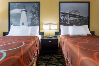 two beds in a hotel room with a lighthouse at Super 8 by Wyndham Wooster in Wooster