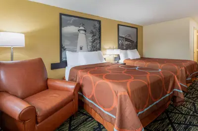 a hotel room with a bed and a chair at Super 8 by Wyndham Wooster in Wooster
