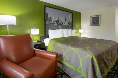 a hotel room with a bed and a chair at Super 8 by Wyndham Wooster in Wooster