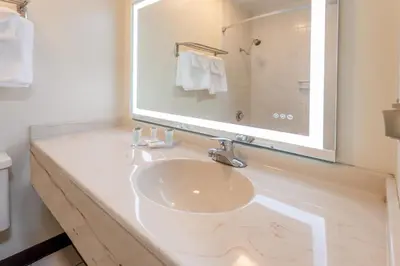 a bathroom with a sink and a large mirror at Super 8 by Wyndham Wooster in Wooster