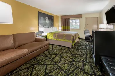 a hotel room with a bed and a couch at Super 8 by Wyndham Wooster in Wooster