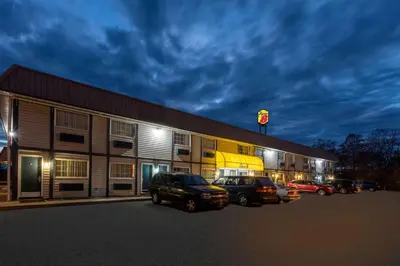 a building with cars parked in a parking lot at Super 8 by Wyndham Wooster in Wooster