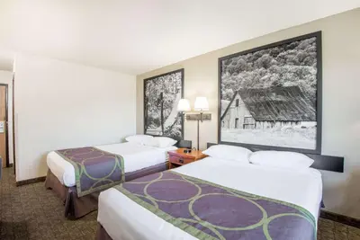 a hotel room with two beds and a picture of a barn at Super 8 by Wyndham Ripley in Ripley