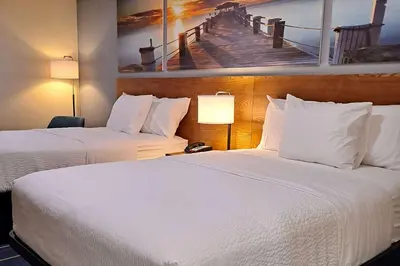 a hotel room with two beds and a picture of a pier at Days Inn by Wyndham Grayson in Grayson