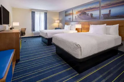 a hotel room with two beds and a flat screen tv at Days Inn by Wyndham Grayson in Grayson