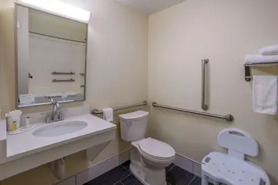 a bathroom with a toilet and a sink and a mirror at Days Inn by Wyndham Grayson in Grayson