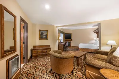 a hotel room with a bed and a living room at Best Western Premier Mariemont Inn in Cincinnati