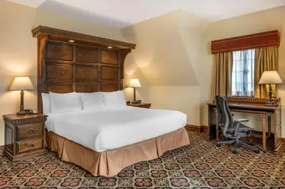 a bedroom with a large bed and a desk and a chair at Best Western Premier Mariemont Inn in Cincinnati