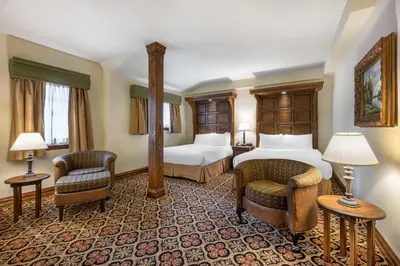 a hotel room with two beds and two chairs at Best Western Premier Mariemont Inn in Cincinnati