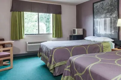 a hotel room with two beds and a window at Super 8 by Wyndham Carrollton in Carrollton