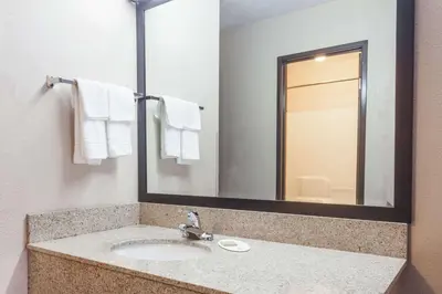 a bathroom with a sink and a mirror at Super 8 by Wyndham Carrollton in Carrollton