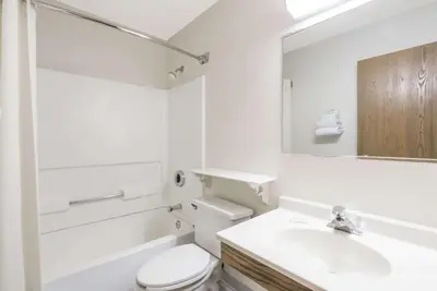 a bathroom with a sink and a toilet and a mirror at Super 8 by Wyndham Maysville KY in Maysville
