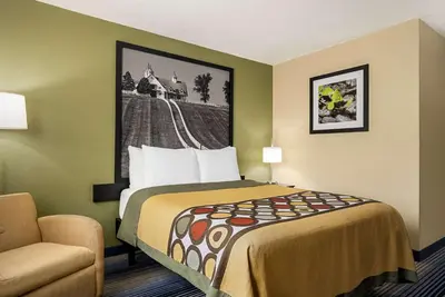 a hotel room with a bed and a chair at Super 8 by Wyndham Maysville KY in Maysville