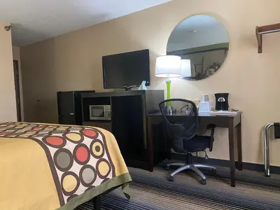 a hotel room with a bed and a desk with a computer at Super 8 by Wyndham Maysville KY in Maysville
