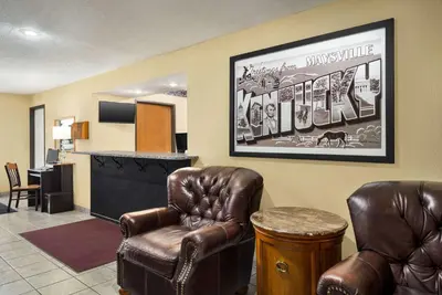 a waiting room with two leather chairs and a counter at Super 8 by Wyndham Maysville KY in Maysville