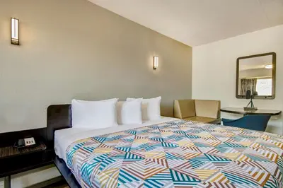 a hotel room with a bed with a colorful comforter at Motel 6 Columbus OH - OSU North in Columbus