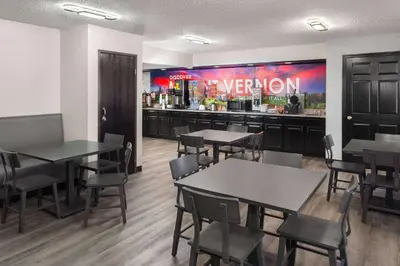 a restaurant with tables and chairs and a bar at Super 8 by Wyndham Mt. Vernon in Mount Vernon