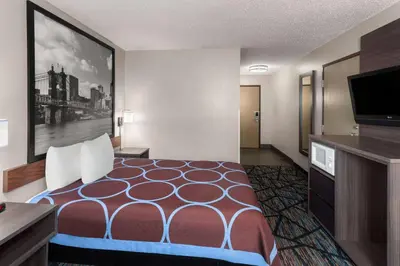 a hotel room with a bed and a flat screen tv at Super 8 by Wyndham Mt. Vernon in Mount Vernon