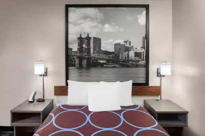 a bedroom with a bed and a picture of a bridge at Super 8 by Wyndham Mt. Vernon in Mount Vernon