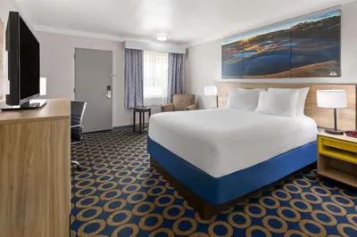 a hotel room with a bed and a flat screen tv at Days Inn by Wyndham Wauseon in Wauseon