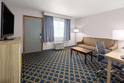 a hotel room with a couch and a television at Days Inn by Wyndham Wauseon in Wauseon