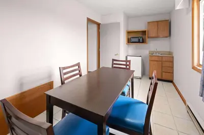 a dining room table with chairs and a kitchen at Days Inn by Wyndham Wauseon in Wauseon
