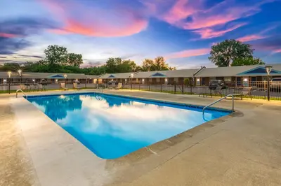 a swimming pool at a resort with a cloudy sky at Days Inn by Wyndham Wauseon in Wauseon