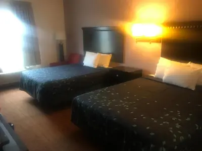 a hotel room with two beds and a lamp at Pier Inn in Luna Pier