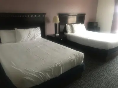 two beds in a hotel room with white sheets at Pier Inn in Luna Pier
