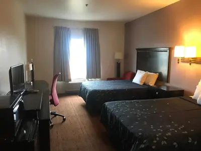 a hotel room with two beds and a desk and a television at Pier Inn in Luna Pier