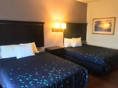 a hotel room with two beds with blue sheets at Pier Inn in Luna Pier