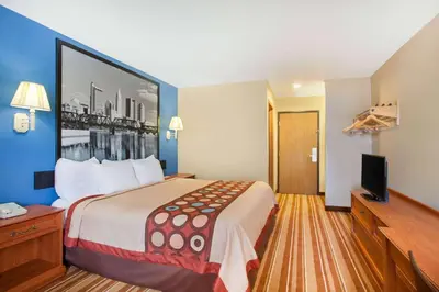 a hotel room with a large bed and a flat screen tv at Super 8 by Wyndham Defiance in Defiance