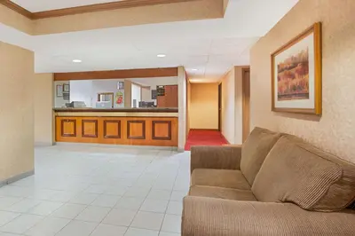 a living room with a couch and a kitchen at Super 8 by Wyndham Defiance in Defiance