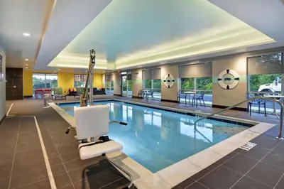 a large swimming pool with a chair in a hotel room at Tru By Hilton Cincinnati Airport South Florence in Florence