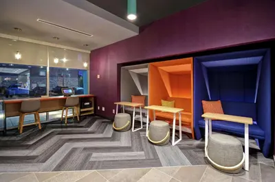 a restaurant with tables and chairs and purple walls at Tru By Hilton Cincinnati Airport South Florence in Florence