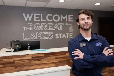 a man standing in front of a counter with his arms crossed at Hampton Inn and Suites Dundee in Dundee