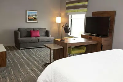 a hotel room with a bed and a desk with a television at Hampton Inn and Suites Dundee in Dundee