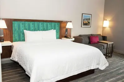 a hotel room with a large white bed and a couch at Hampton Inn and Suites Dundee in Dundee