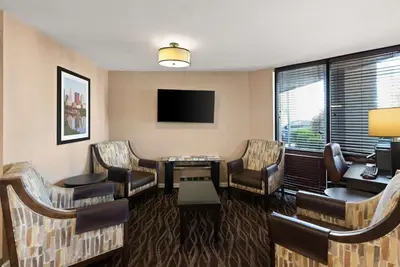 a hotel room with chairs and a table and a tv at Best Western Executive Inn in Grove City